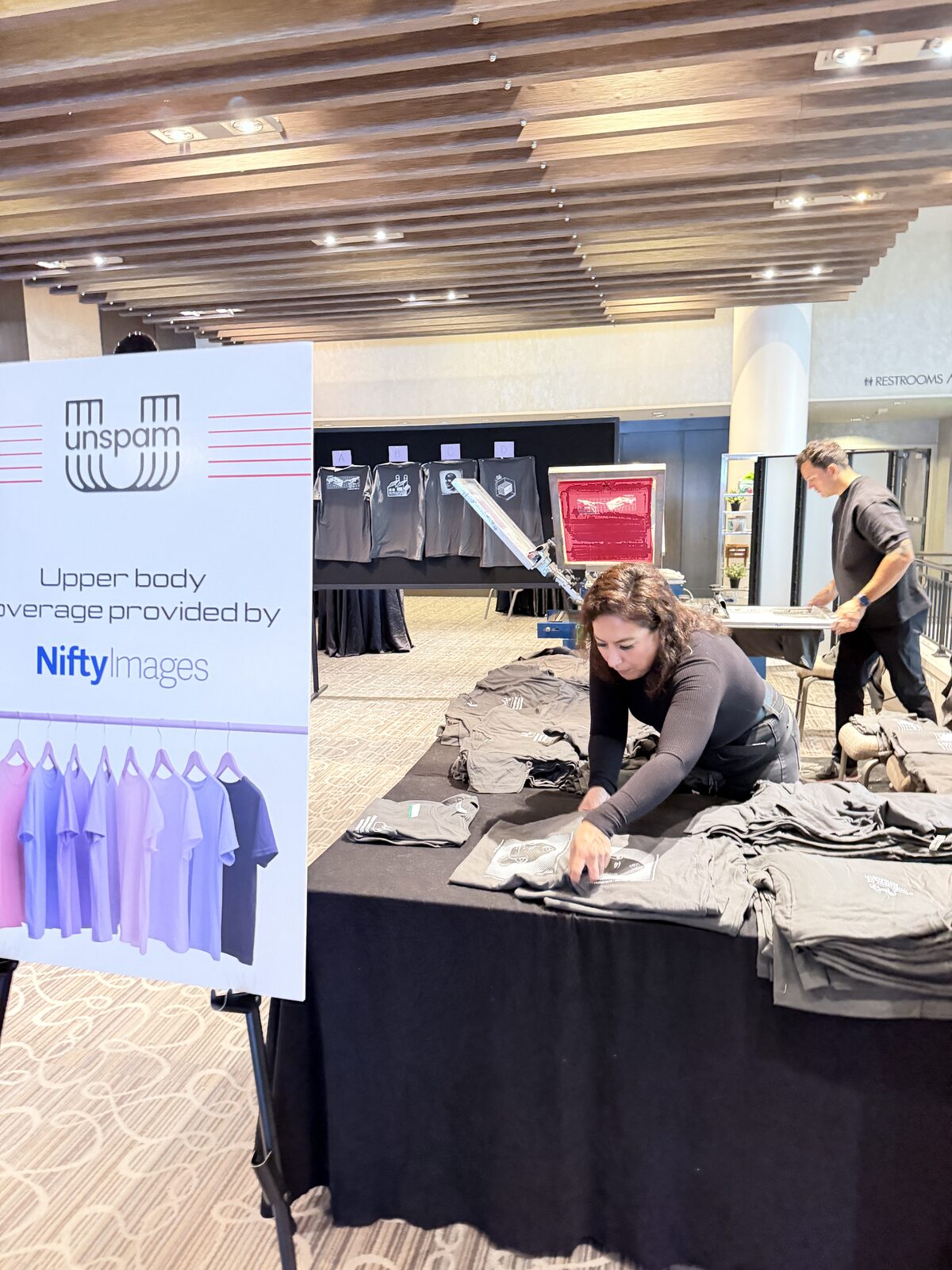 Folded shirts and event merch table representing live jersey customization
