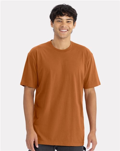 Model wearing a blank burnt-orange Next Level 3600 tee