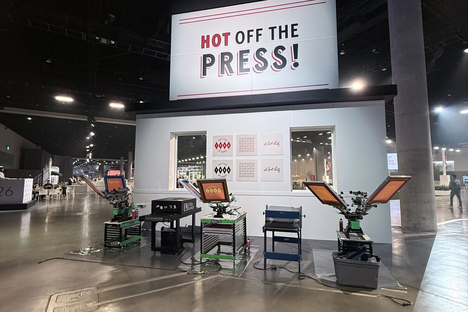 Hot Off The Press trade-show booth with three screen-printing presses at a convention center